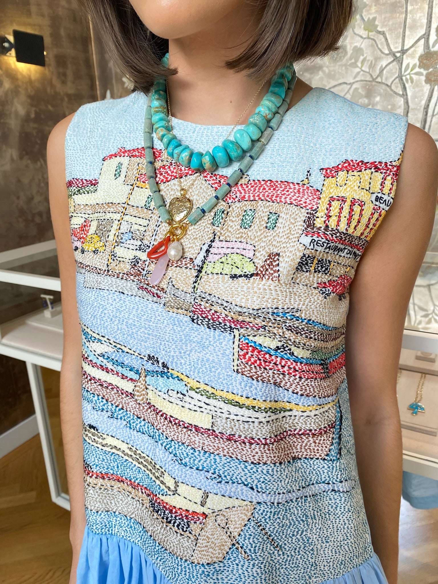 MII | EMBROIDERED KANTHA MIDI DRESS Woman in a sleeveless top and blue skirt standing in a room with decorative wall, Charlotte, NC