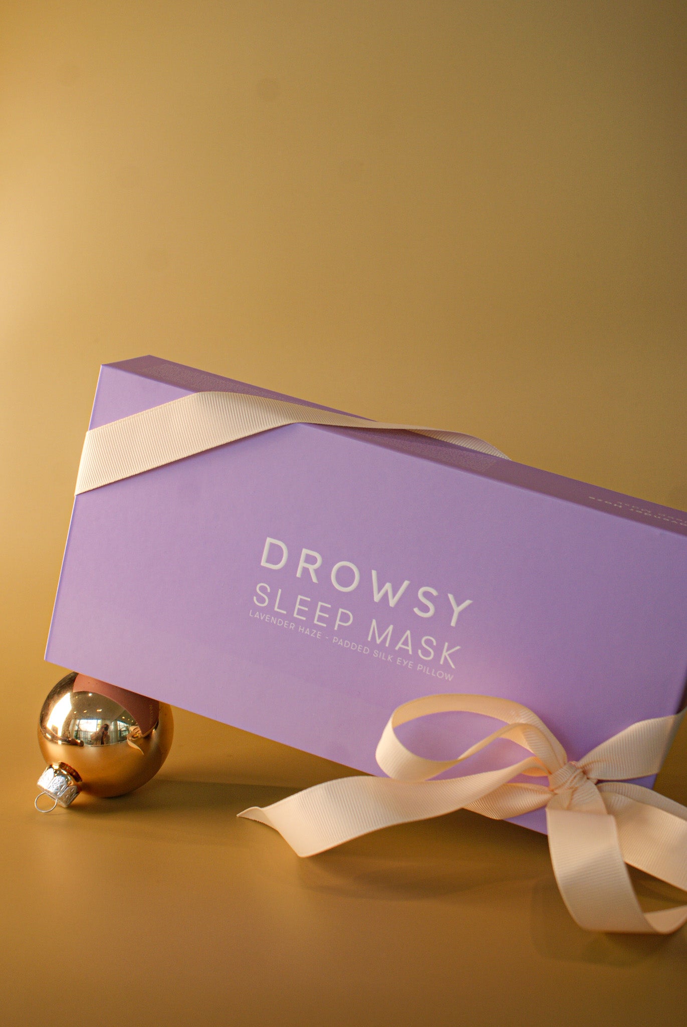 DROWSY | SIK SLEEP MASK shown in a purple box on a matte gold background, Charlotte, NC