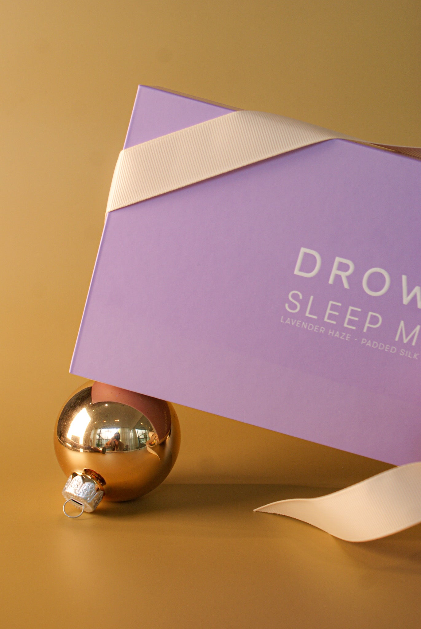 DROWSY | SIK SLEEP MASK shown in a purple box on a matte gold background, Charlotte, NC